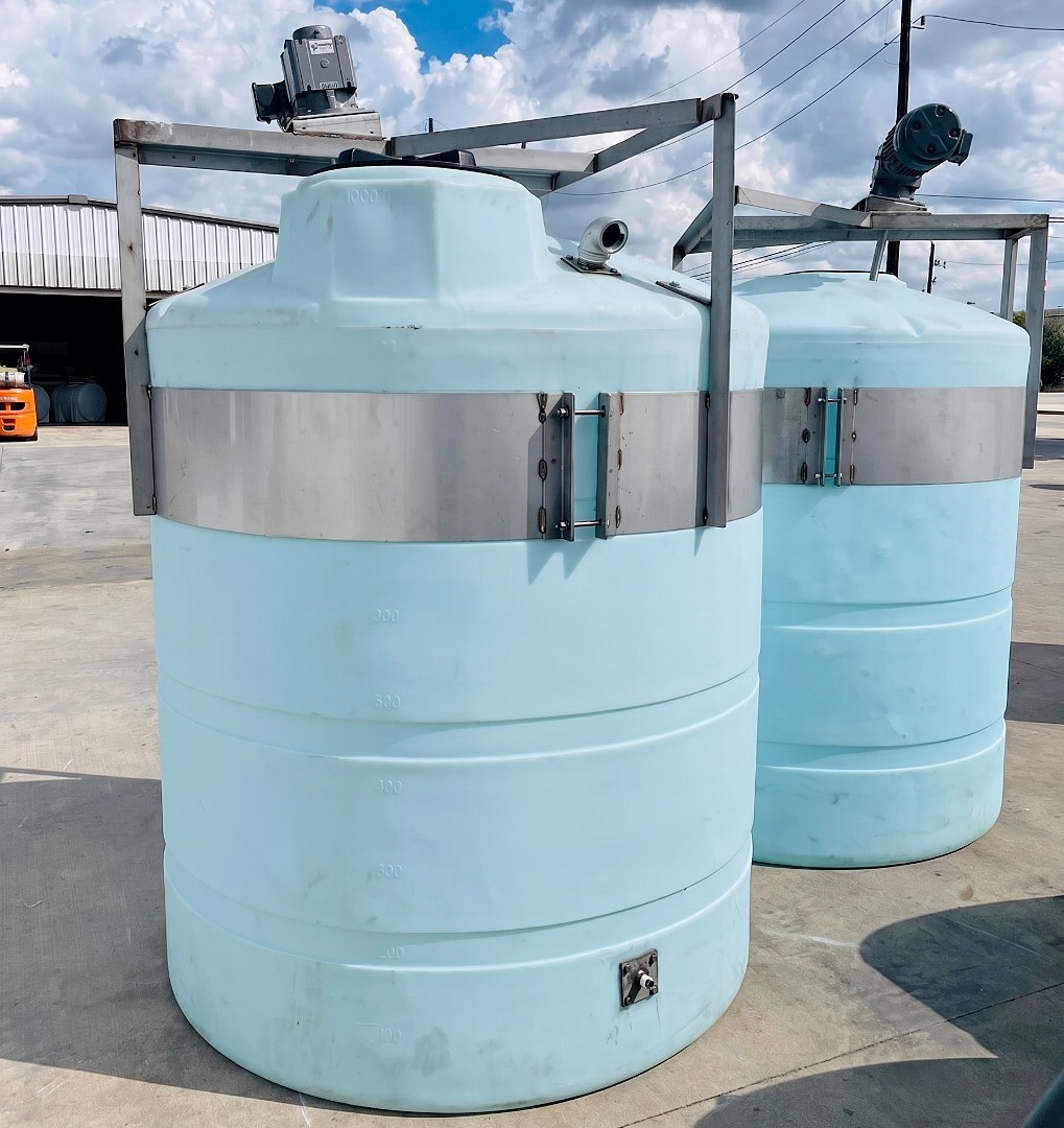 Two vertical polyethylene tanks with steel reinforcement bands and top mounted mixers for industrial agitation and blending