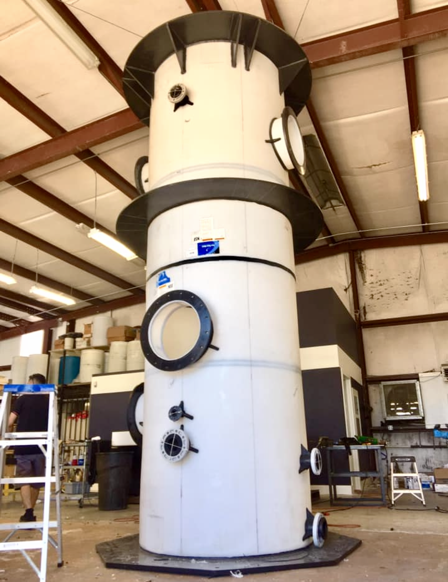 A tall industrial vertical fume scrubber tower fabricated from polypropylene with multiple large flange connection ports