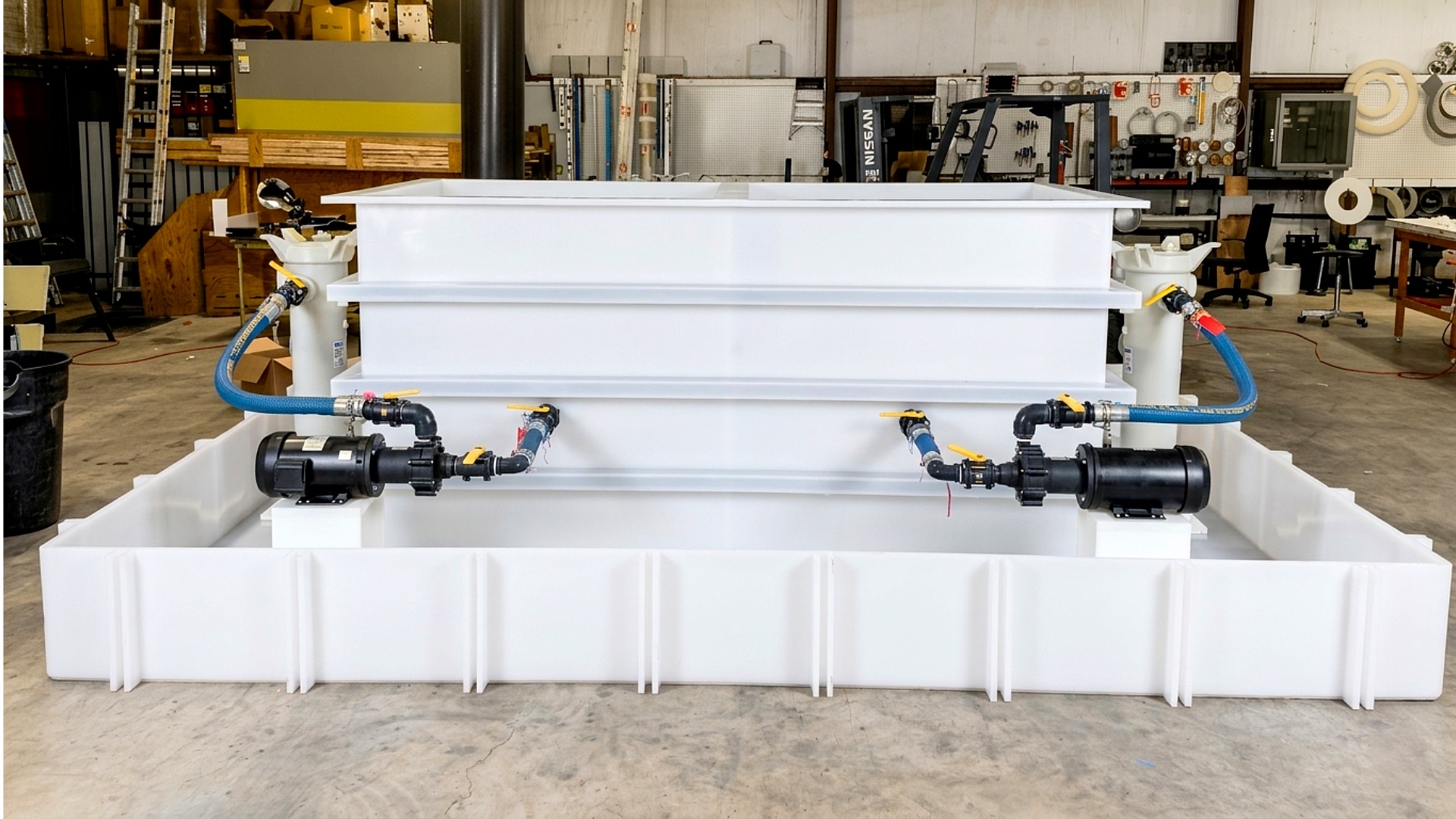 A custom plastic processing system with a central rectangular tank, external filter housing, and electric pump all in a secondary containment basin