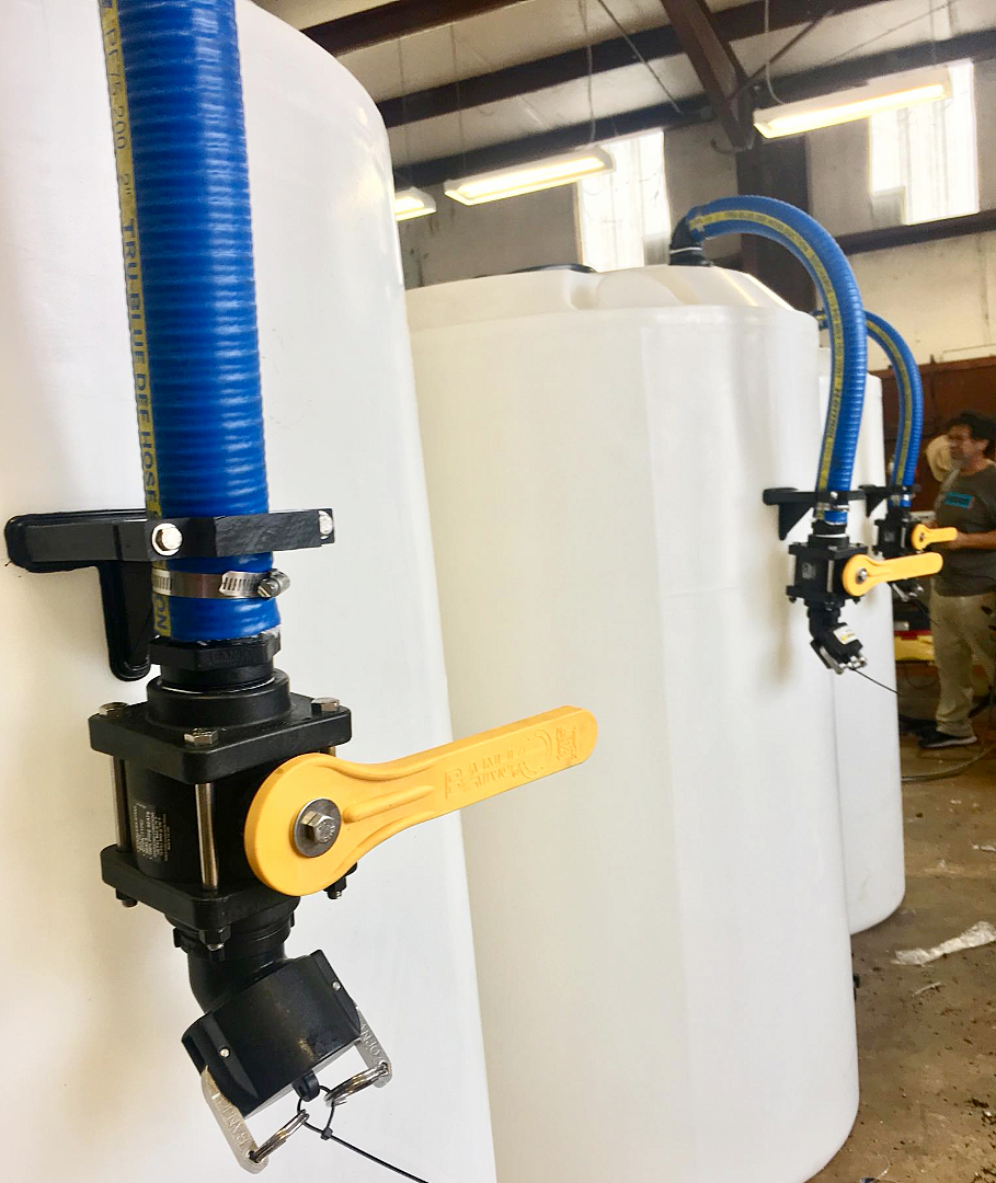 A row of three polyethylene storage tanks with blue flexible 