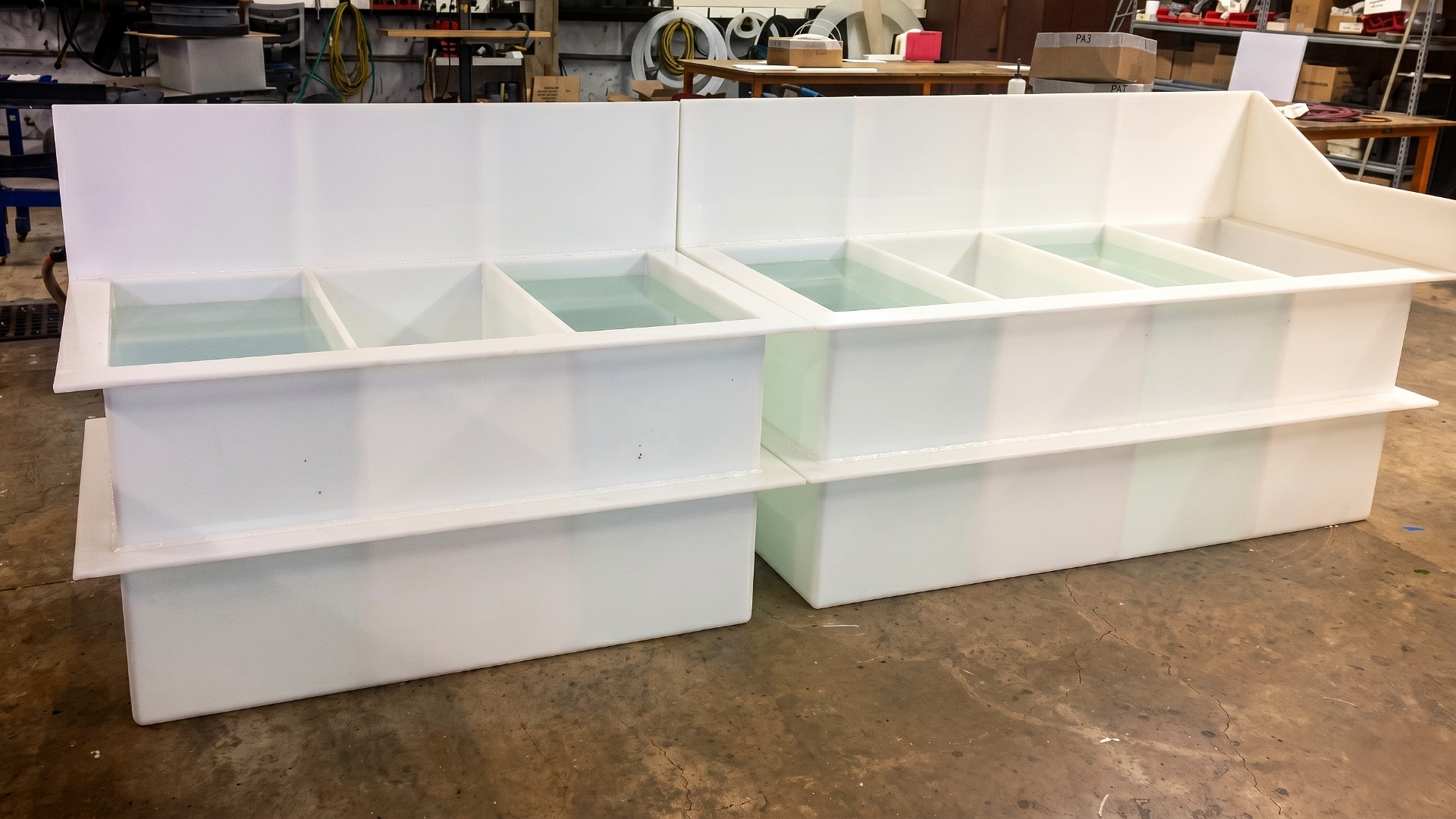 Two custom-made white polypropylene multi-compartment dipping or washing tanks with splash-guard backs
