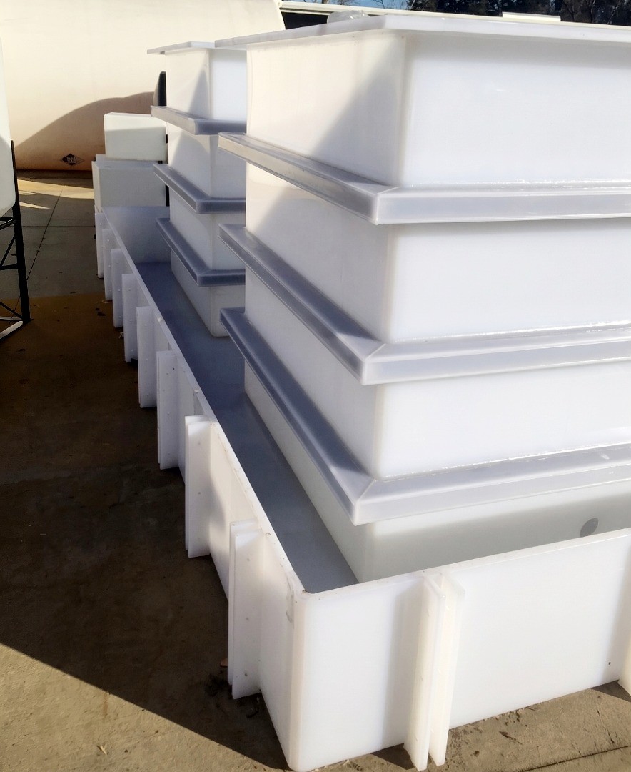 Multiple custom fabricated polypropylene rectangular tanks staged on an integrated secondary containment basin