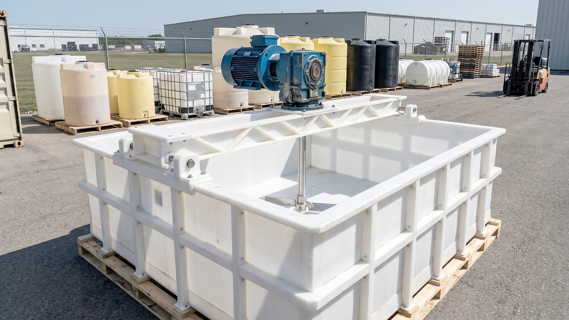 Custom white polypropylene tank with custom mixer attachment on pallets in stock yard for shipment
