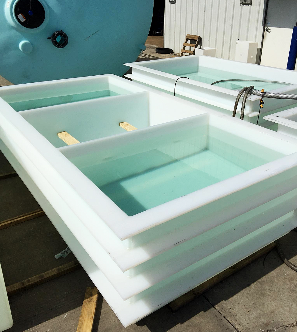 Custom fabricated polypropylene tanks with baffles filled with water, undergoing leakproofness testing