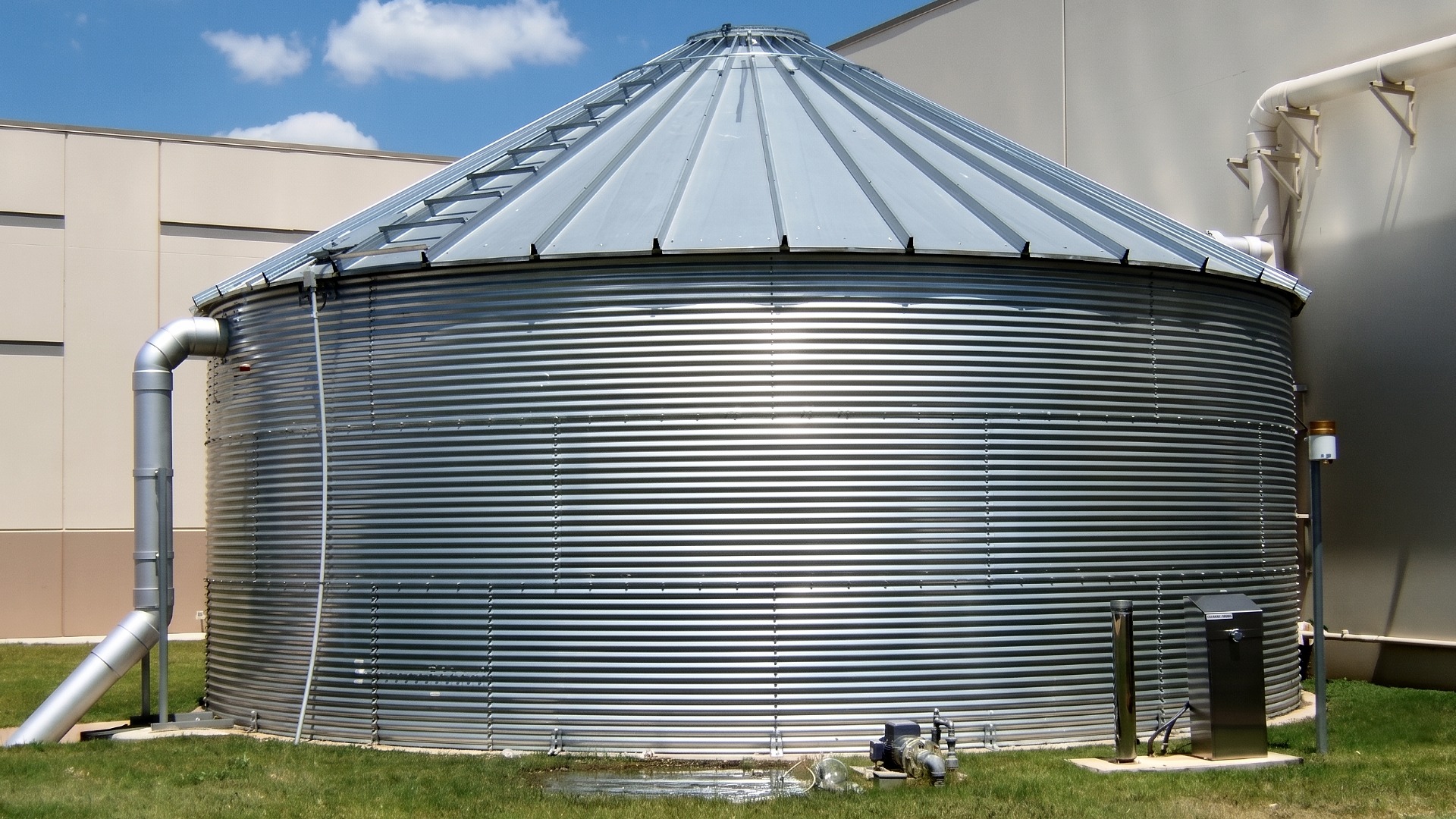 A large storage volume galvanized steel tank installed for use in rainwater harvesting capture for water conservation and sustainability