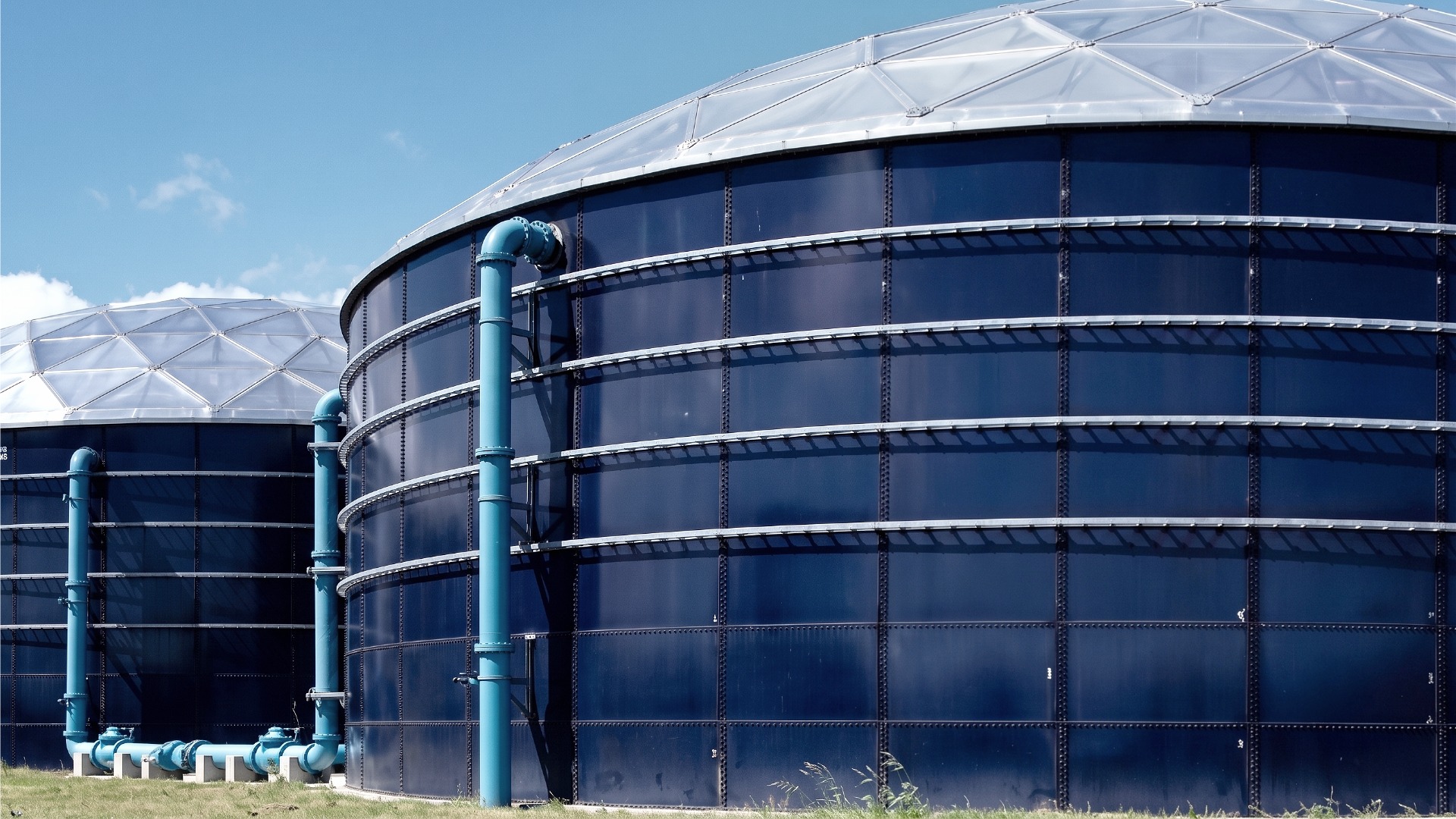 An image showing two dome shaped, blue and white steel bolted storage tanks joined in sequence for data center makeup water reserves