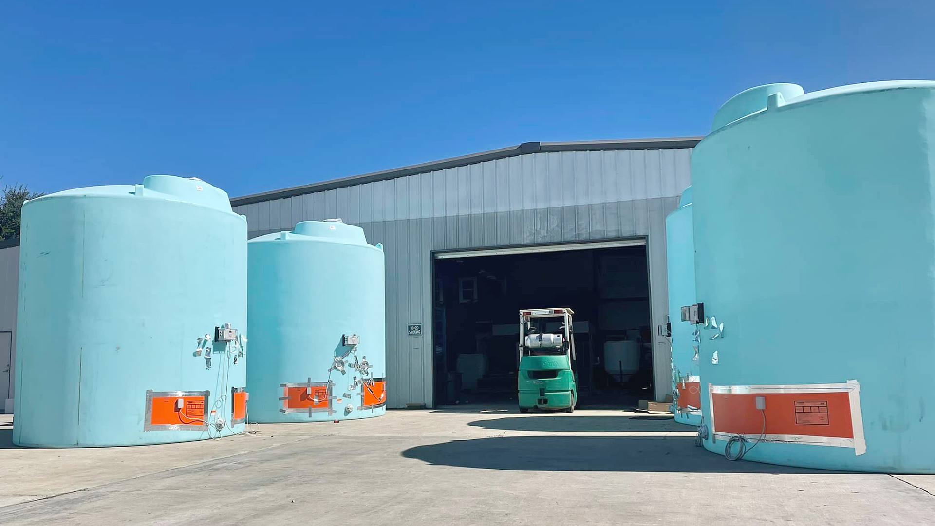 Four polyethylene storage tanks equipped with heat trace pads and electronic controllers for temperature controlled chemical storage