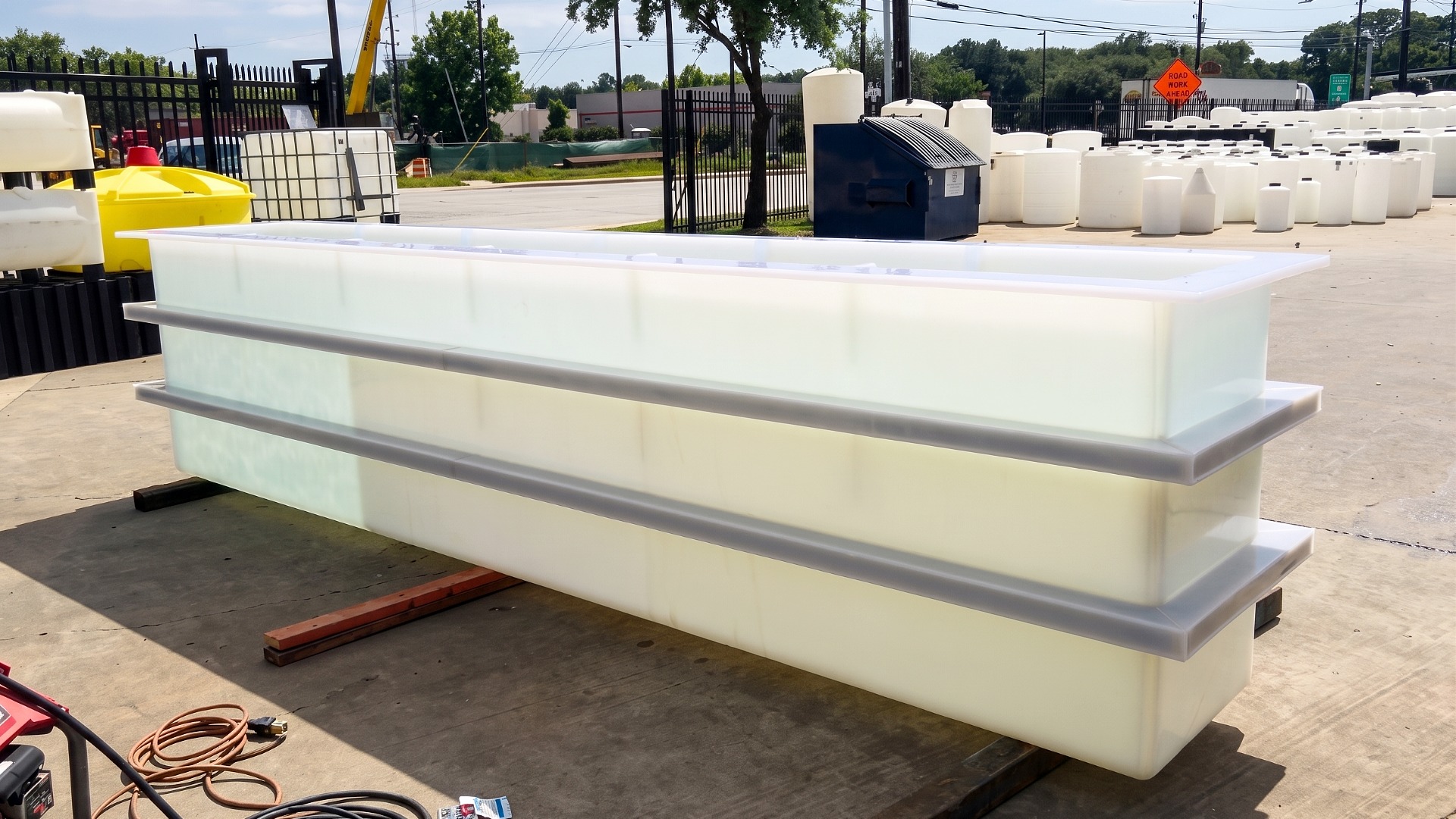 A long, white, custom made rectangular plastic tank with horizontal reinforcement ribs