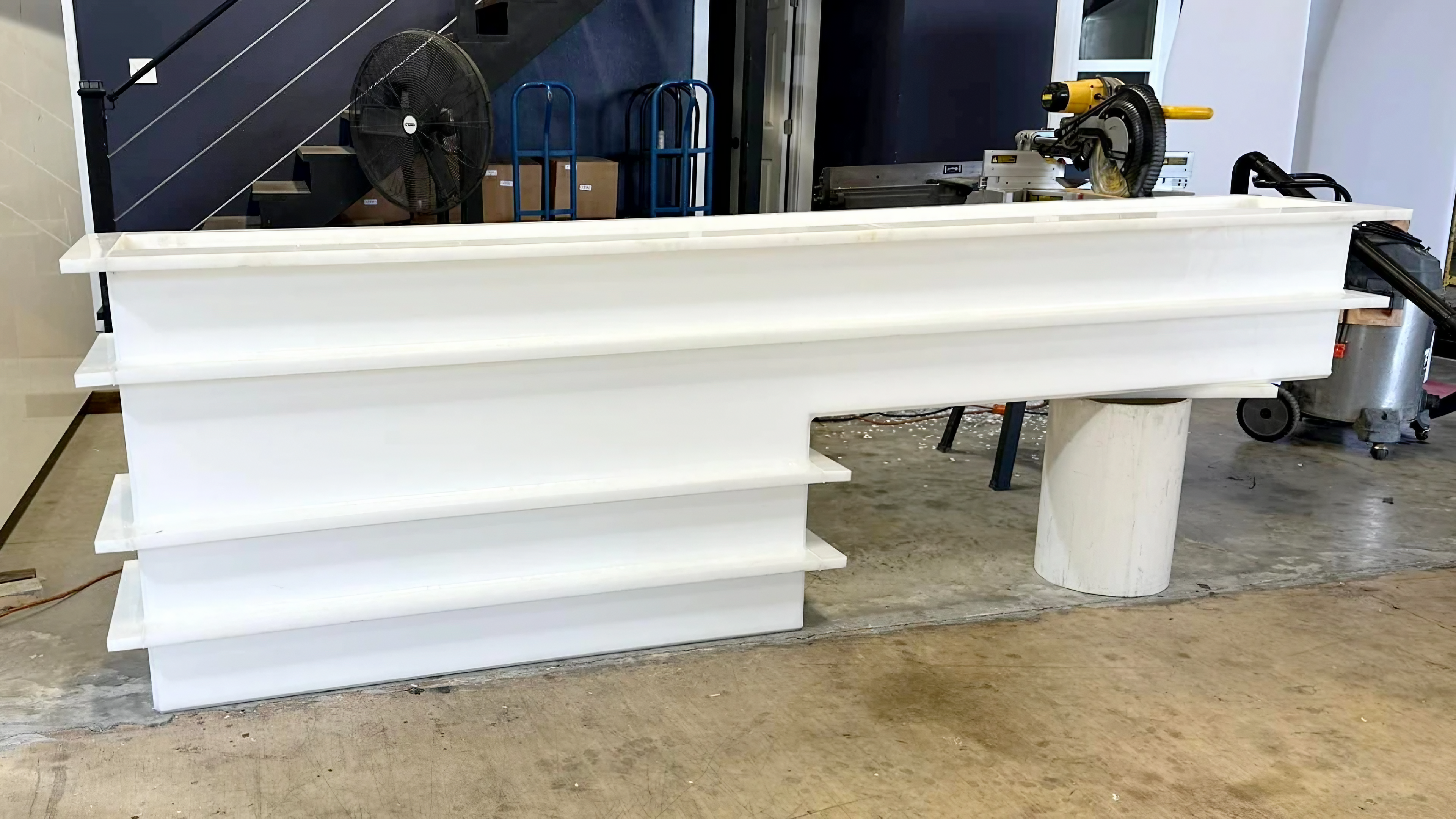 A side profile of a long, narrow custom PP rinse and wash tank with reinforcement ribs for structural integrity