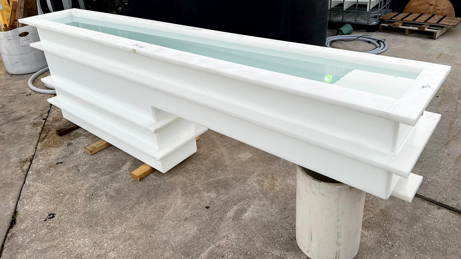 A long, custom-made polypropylene rinse and dip tank filled, showing a trough-like design with reinforcement ribs