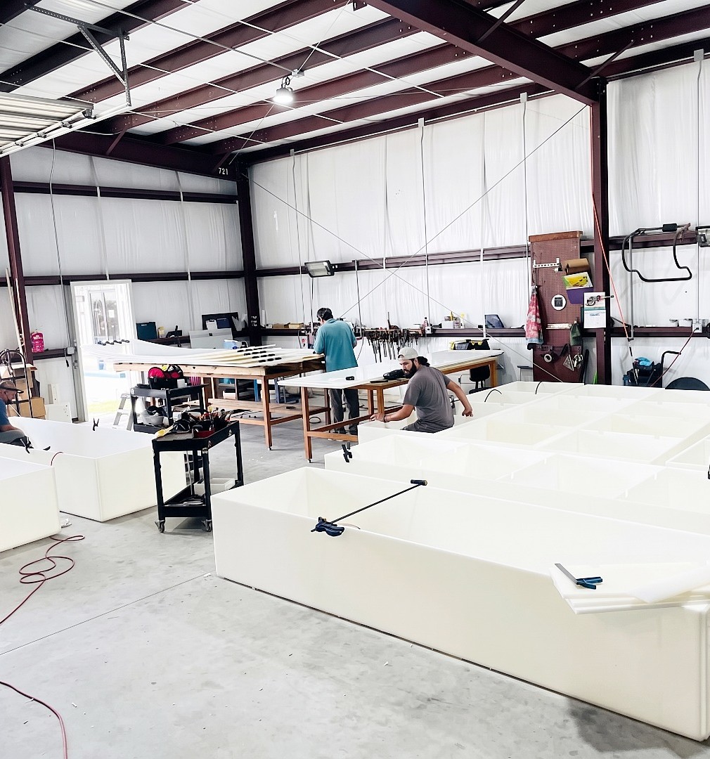 An image of the Protank custom tank fabrication team at work welding together large polypropylene tanks