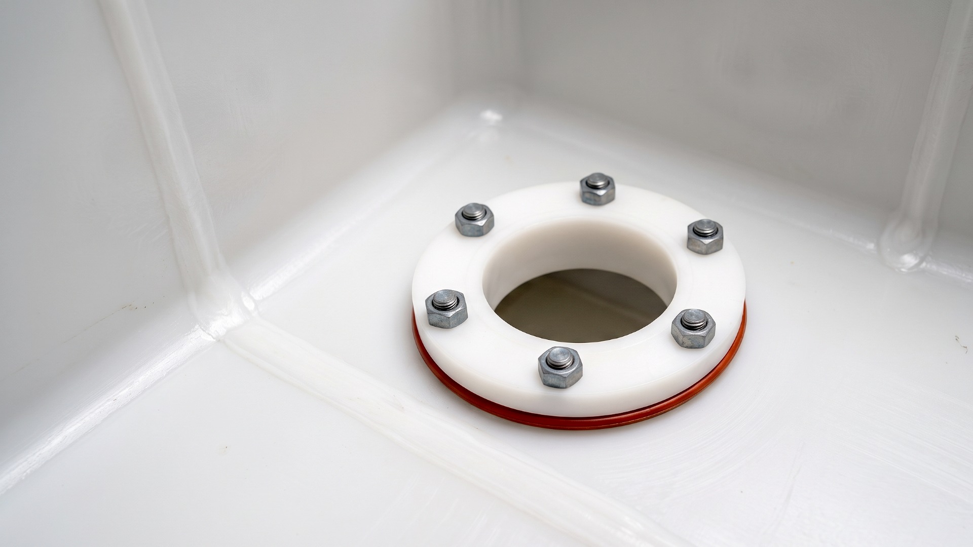 A close up of a PVDF flange drain fitting with compatible steel hardware and Viton gasket.
