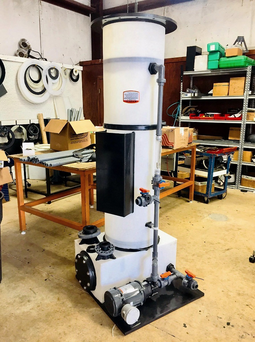 Industrial tank assembly with tall white vertical cylinder on a rectangular base with pump and PVC piping